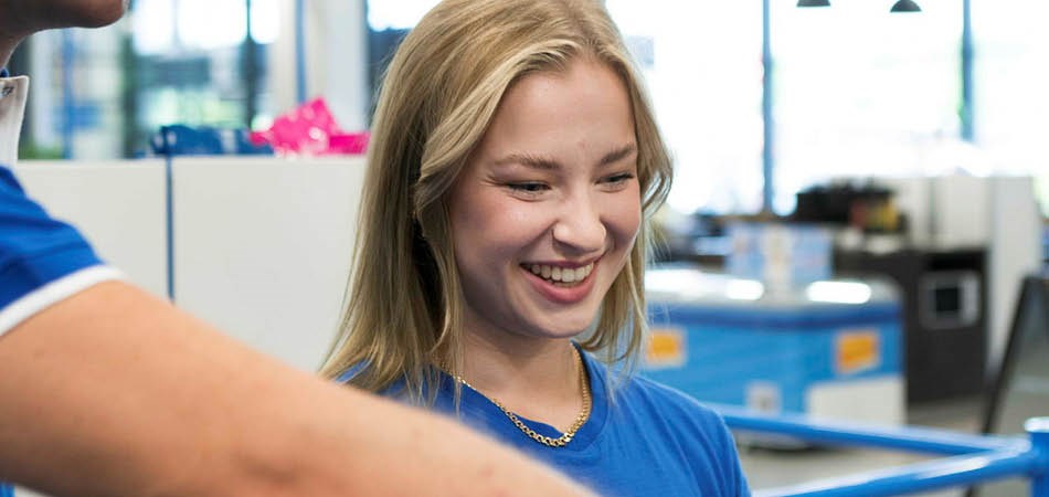 Biltema anställd vid kassan med ett leende