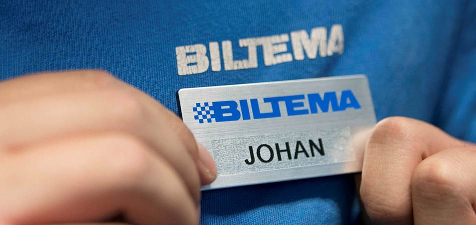 Biltema anställd som håller i sin namnbricka.