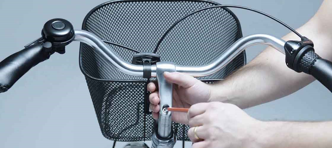 Närbild på en hand som justerar ett cykelstyre.
