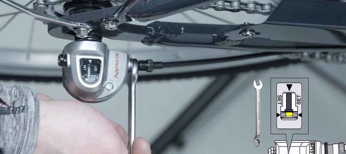 Närbild av en hand som justerar en cykels växlar som är av märket Nexus.
